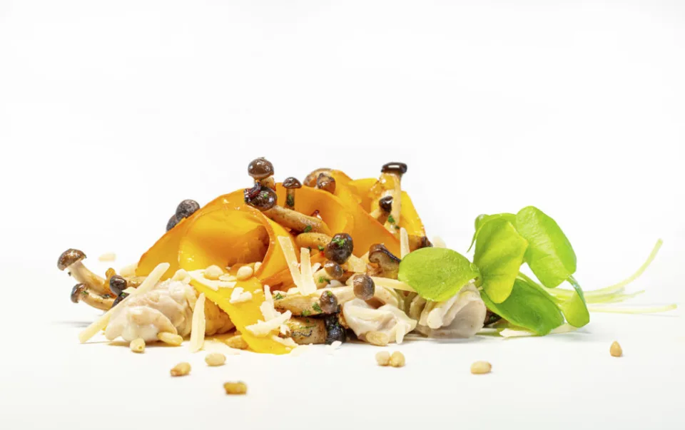 Kürbis mit Pilzen, Pinienkernen und Kräutern