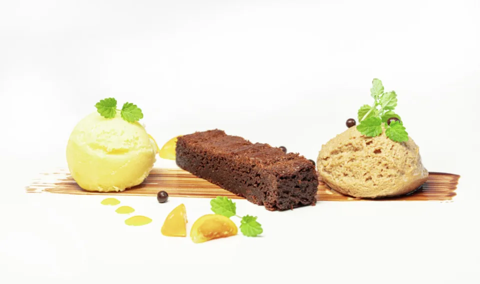 Dessert mit Eiscreme, Brownie und Fruchtsauce