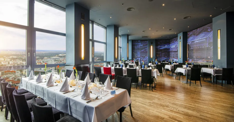 Festlich eingedeckte Tafel im Restaurant mit Blick über Leipzig