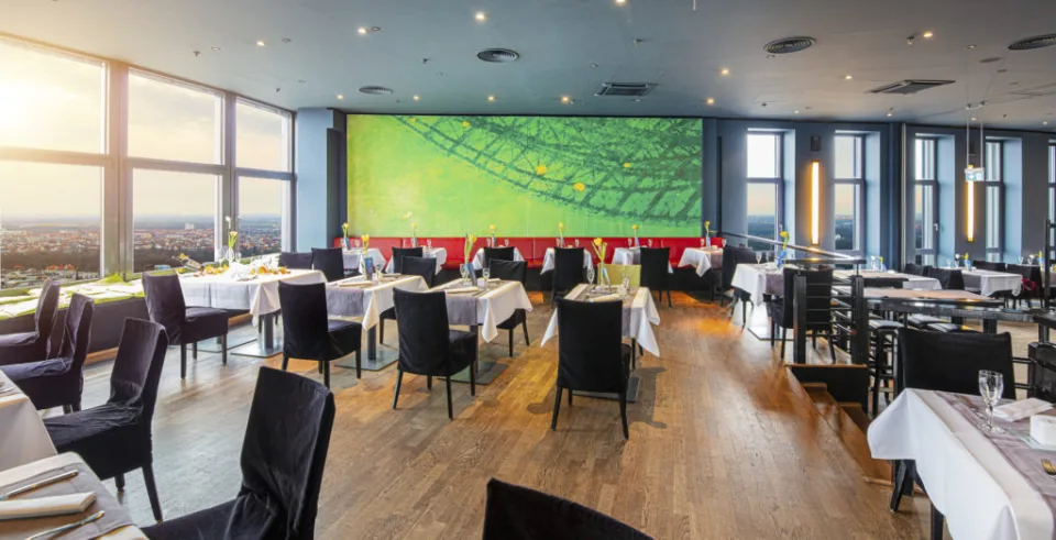 Restaurant mit grünem Wandbild und gedeckten Tischen